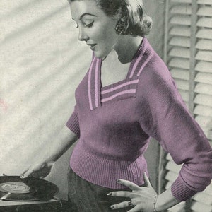 May include: A vintage-style image features a woman wearing a purple sweater with a square neckline and light pink stripes. The sweater has short sleeves and a ribbed hem. She is standing near a record player, with one hand on the record.