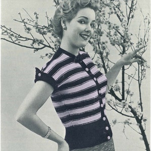 May include: A vintage black and light purple striped cardigan with short sleeves and button closures. The woman is wearing a bracelet and earrings. The background features a flowering tree.
