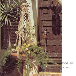 Könnte beinhalten: Ein Vintage-Makramee-Pflanzenaufhänger mit einem rechteckigen Terrakotta-Topf, gefüllt mit grünem Laub und gelben und orangefarbenen Blumen. Der Pflanzenaufhänger hängt vor einer dunklen Holztür. Der Text auf dem Bild lautet "Sofort-Download PDF Vintage-Muster."