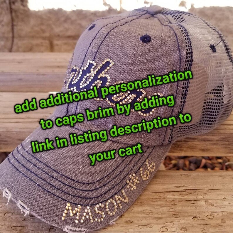Puede incluir: Una gorra de b&eacute;isbol gris y negra con una parte trasera de malla. La gorra tiene una visera azul marino y est&aacute; decorada con diamantes de imitaci&oacute;n dorados. El texto "MASON #66" est&aacute; escrito en diamantes de imitaci&oacute;n en la parte delantera de la gorra. El texto "add additional personalization to caps brim by adding link in listing description to your cart" est&aacute; escrito en texto verde en la imagen.