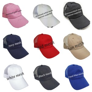 May include: Ten different colored trucker hats with mesh panels. The hats are in various colors including pink, white, black, navy, red, tan, white, black, and royal blue. The hats have distressed and contrast underbill options.