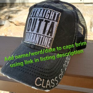 Może przedstawiać: Czarna siatkowa czapka trucker z przetartym denimowym przodem. Prz&oacute;d czapki zdobi biały naszywka z tekstem "STRAIGHT OUTTA QUARANTINE" pogrubioną czcionką. Czapka ma r&oacute;wnież kryształki wok&oacute;ł naszywki i napis "CLASS OF 2020" na daszku.