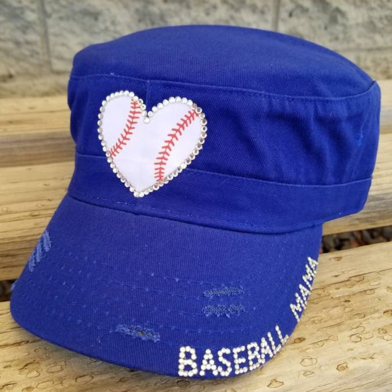 Pode incluir: Bon&eacute; de beisebol azul com um design de beisebol em forma de cora&ccedil;&atilde;o branco. O bon&eacute; tem as palavras "Baseball Mama" em strass brancos na aba. O bon&eacute; tem um visual desgastado.