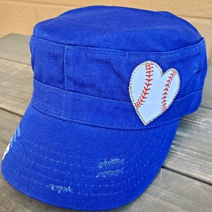 Pode incluir: Bon&eacute; azul royal de estilo militar com aba desgastada. Um patch branco em forma de cora&ccedil;&atilde;o, adornado com strass, apresenta um design de beisebol com costuras vermelhas. O bon&eacute; tem uma coroa estruturada e uma pequena viseira.
