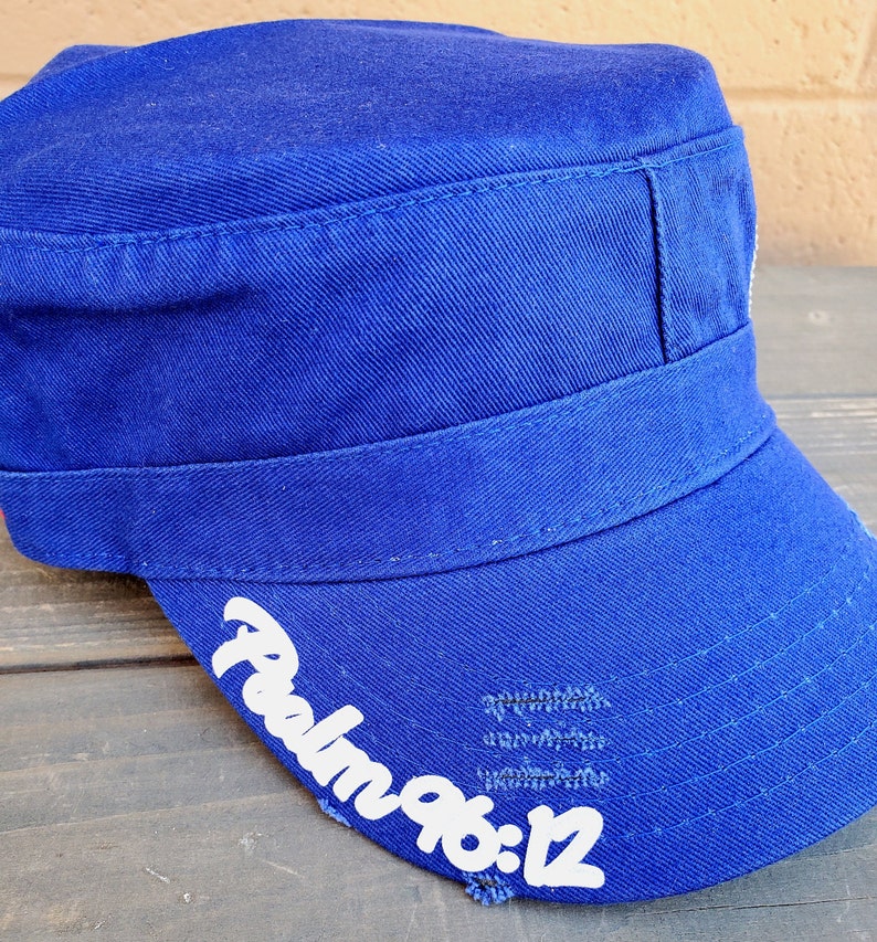 Pode incluir: Bon&eacute; azul royal de estilo militar com aba reta e coroa estruturada. O texto "Psalm 96:12" est&aacute; impresso em branco na aba. O bon&eacute; tem um visual desgastado.