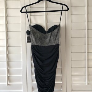 May include: A black strapless dress with a silver and black patterned bodice and a ruched skirt.