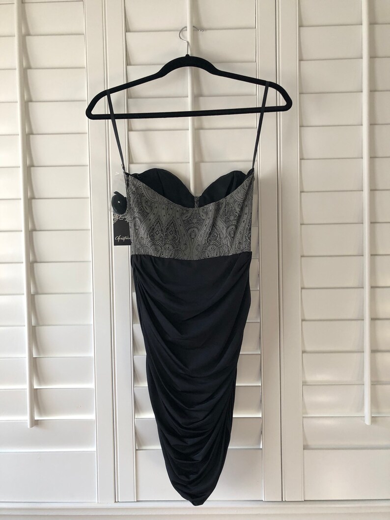May include: A black strapless dress with a silver and black patterned bodice and a ruched skirt.