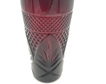 May include: A deep red glass tumbler with a diamond pattern and a leaf design. The glass is clear and has a smooth finish.