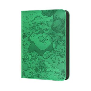 May include: Green card binder featuring a detailed illustration of a Snorlax and Pikachu resting in a forest scene. The binder has a zipper closure and a black spine. The cover art is a detailed, cartoon-style drawing.