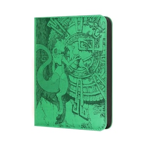 May include: A bright green rectangular card binder featuring a dark green etched illustration of a bipedal creature with a long tail standing before a large circular stone-like structure with intricate geometric patterns and ancient carvings.
