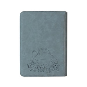 May include: A gray card binder featuring a line drawing of Snorlax and other Pok&eacute;mon characters. The binder has a textured surface and a dark gray border. The design is a simple, yet appealing, illustration for fans of the franchise.