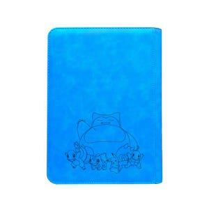May include: A blue card binder featuring a black line drawing of Snorlax and other Pok&eacute;mon characters. The binder has a textured surface and a stitched border, perfect for storing trading cards.