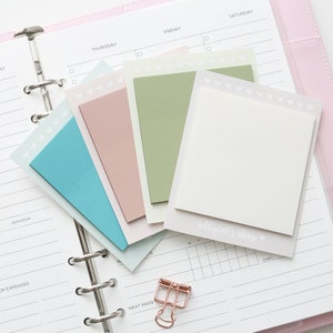 May include: A set of pastel coloured sticky notes with a white heart pattern border. The notes are on a white planner with the words "THURSDAY", "FRIDAY", and "SATURDAY" visible. The notes are labelled "allycat's shop".