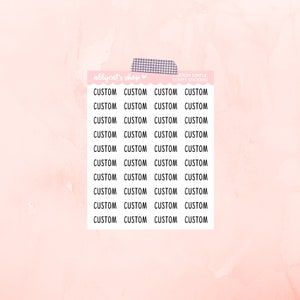 May include: A sheet of 24 white custom script stickers on a pink background. The stickers are arranged in four rows of six stickers each. Each sticker says "CUSTOM" in black text.