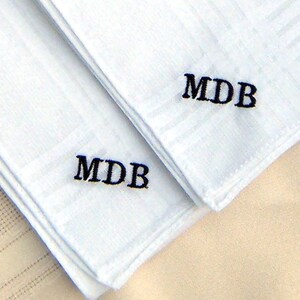 May include: Two white handkerchiefs with black embroidered initials "MDB" on each.