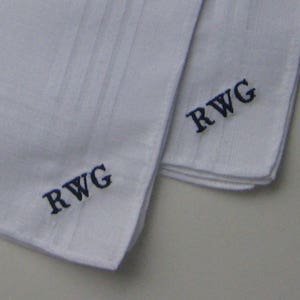 May include: Two white handkerchiefs with blue embroidered initials "RWG" on each.