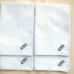 May include: Four white handkerchiefs with a subtle embossed pattern and the initials "GTO" embroidered in the corner.
