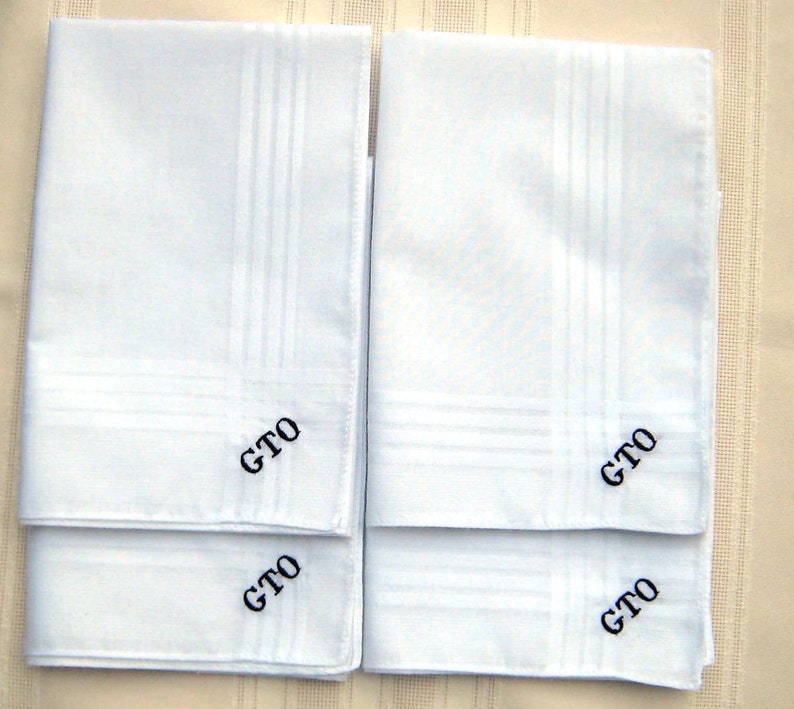 May include: Four white handkerchiefs with a subtle embossed pattern and the initials "GTO" embroidered in the corner.