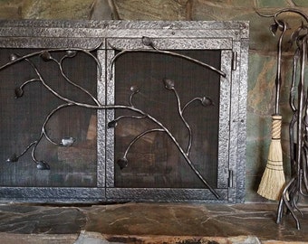Wrought iron fireplace screen door set with matching tools. Branches and leaves.