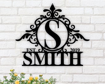 May include: Black metal monogram sign with a decorative scroll design and the letter "S" in a circle. The sign also includes the text "EST 2019" and the last name "SMITH".