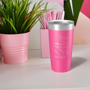 May include: Pink stainless steel tumbler with a silver lid. The tumbler has the name "Katelyn" and the word "bridesmaid" engraved on it.