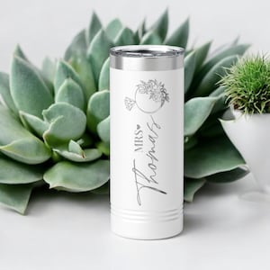 May include: White stainless steel tumbler with a silver lid. The tumbler has a floral design and the text "MRS. Thomas" in a cursive font.