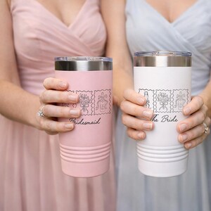 May include: A light pink tumbler with the text Bridesmaid and a white tumbler with the text The Bride. Both stainless steel insulated cups feature a clear lid and a black line art graphic of a champagne flute, a floral bouquet, and a bottle.