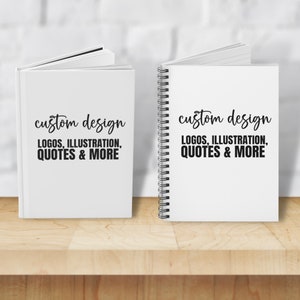 May include: Two white notebooks with black text that reads "custom design logos, illustration, quotes & more". One notebook is a spiral bound notebook and the other is a hardcover notebook.