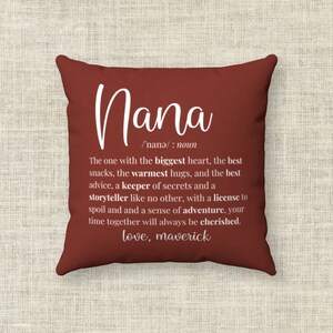 May include: Red throw pillow with white text defining "Nana" as "The one with the biggest heart, the best snacks, the warmest hugs, and the best advice, a keeper of secrets and a storyteller like no other, with a license to spoil and a sense of adventure, your time together will always be cherished. love, maverick"