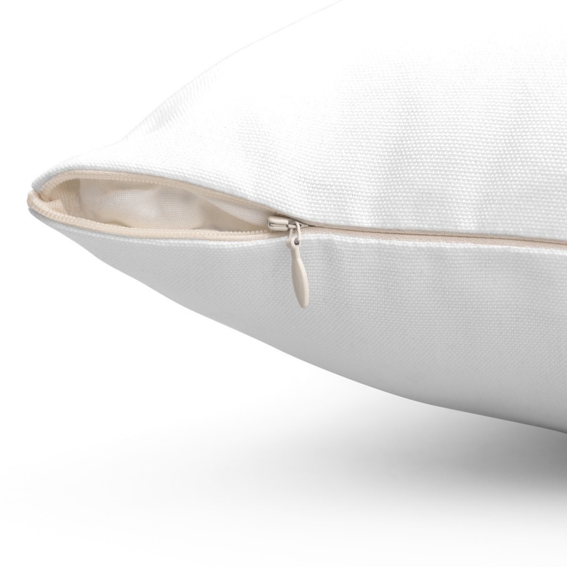May include: A white pillow cover with a zipper closure. The zipper is visible and is open.