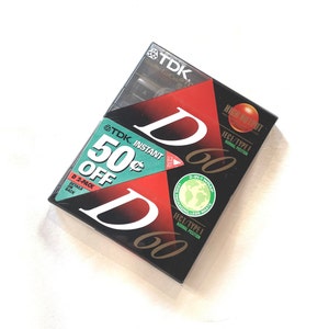 May include: A package of TDK D60 audio cassette tapes. The packaging is black and red with white lettering, including "D60" and "50&cent; OFF." The package also features a "High Output" label and a "2-in-1 Wrap" sticker.