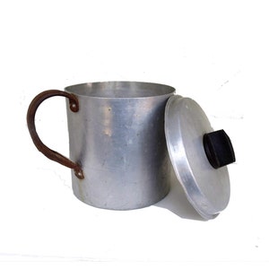 Rustic primitive vintage aluminum pot with a lid and large rusty handle