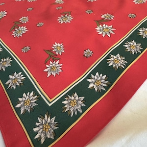 May include: A set of three ceramic mugs with a speckled, cream-colored glaze. Each mug features a different hand-painted design: a blue and green leaf, a yellow flower, and a red berry. The mugs have a simple, rounded shape.