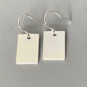 May include: A pair of silver square earrings with a simple design. The earrings have a hook fastening.