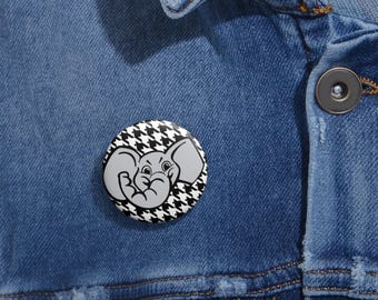 May include: A round button pin featuring a gray elephant illustration on a black and white houndstooth pattern. The pin is attached to a blue denim jacket.