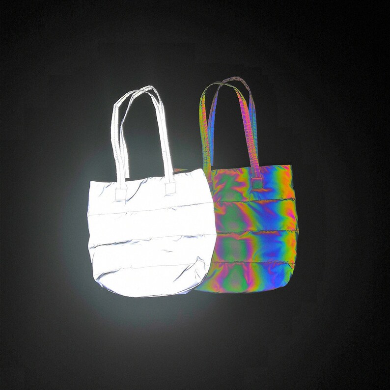 May include: Two tote bags made of quilted fabric. One bag is silver reflective and the other is iridescent.