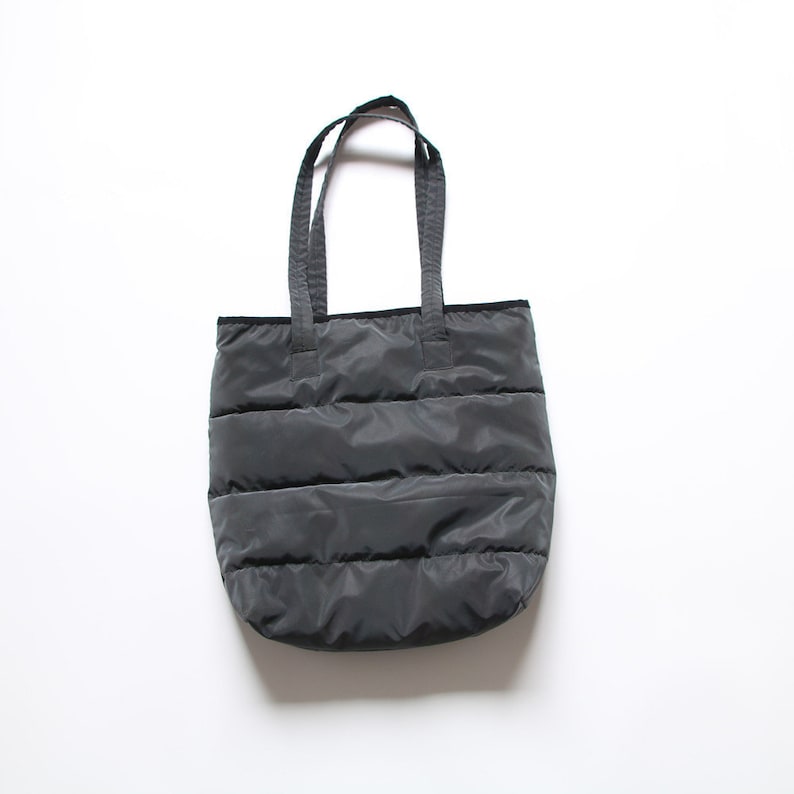 May include: A black quilted tote bag with two handles.