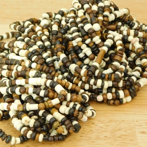 May include: A pile of wooden beads in brown, black, and white colors. The beads are strung together in a long strand.