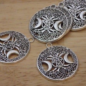 May include: Silver-toned metal charms with a triple moon and pentagram design. The charms have a Celtic knot border and are perfect for jewelry making.
