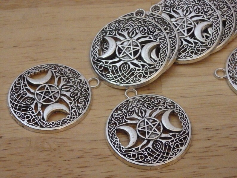 May include: Silver-toned metal charms with a triple moon and pentagram design. The charms have a Celtic knot border and are perfect for jewelry making.
