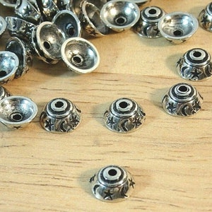 May include: Silver metal bead caps with a moon and star design. The caps are about 1/2 inch in diameter.