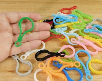 May include: Assortment of colorful plastic keychains in various shapes and sizes. The keychains are made of a flexible plastic material and feature a variety of bright colors, including green, blue, yellow, orange, pink, and red.