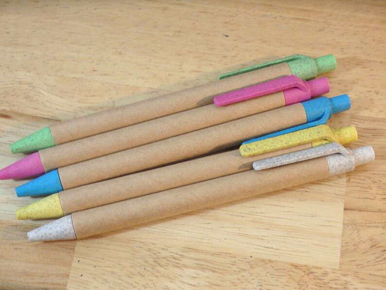 Op de afbeelding: Vijf bruine kartonnen pennen met verschillende gekleurde dopjes. De dopjes zijn groen, roze, blauw, geel en wit.