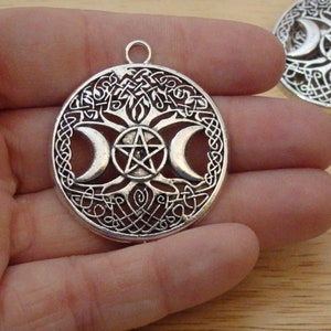 May include: Silver pendant featuring a tree of life design with three crescent moons and a pentagram. The pendant is intricately detailed and has a Celtic knot border.