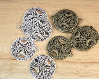 May include: A set of six metal charms featuring a triple moon and pentagram design. Three charms are silver and three are bronze.