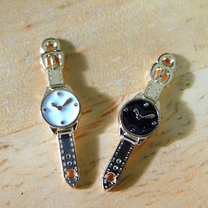 May include: Two gold-tone wristwatches with black leather bands. One watch has a white face with black hands and the other has a black face with gold hands.