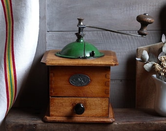 Antique french wooden coffee grinder with green metal top. French country kitchen. Rustic farmhouse decor. Manual coffee grinder