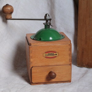 Vintage french wooden coffee grinder with green metal top. French country kitchen. Rustic farmhouse decor. Manual coffee grinder