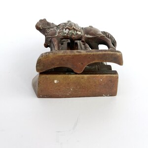 May include: A bronze sculpture of a rider on horseback, the horse is standing on a base with a decorative design. The sculpture is a paperweight.