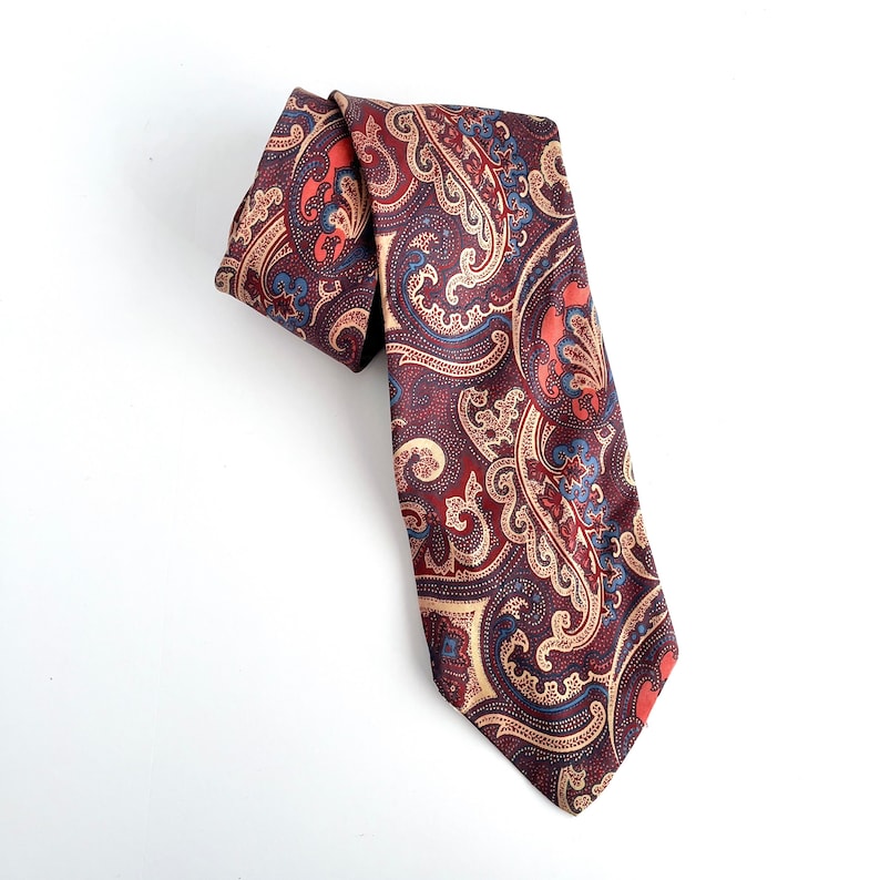 May include: A brown paisley patterned tie with red, blue, and gold accents.
